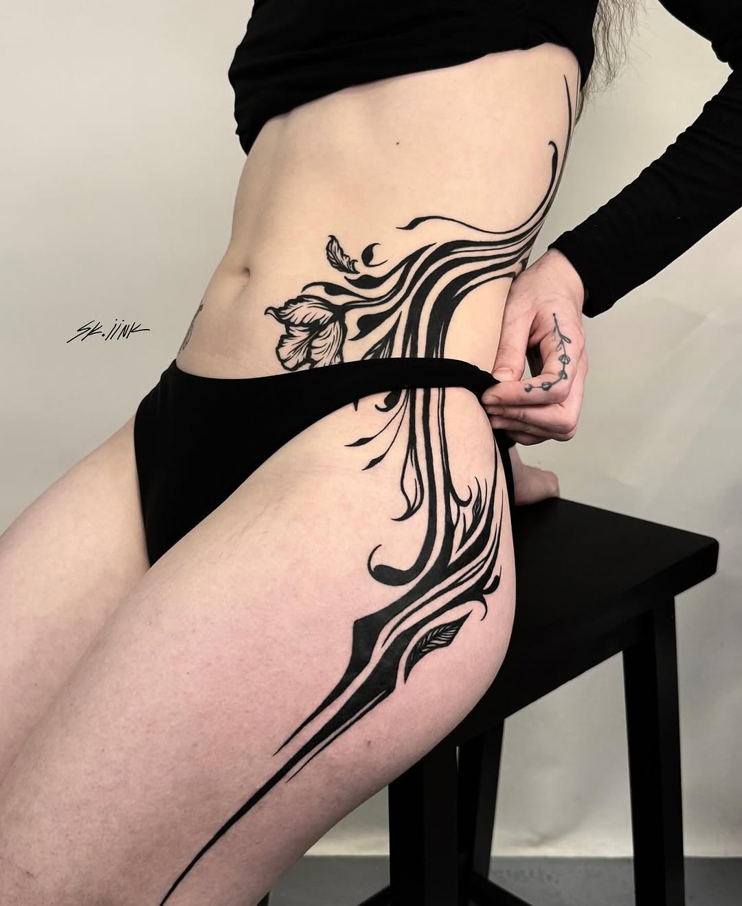 Tattoo by @sk.iink — illustrative, blackwork