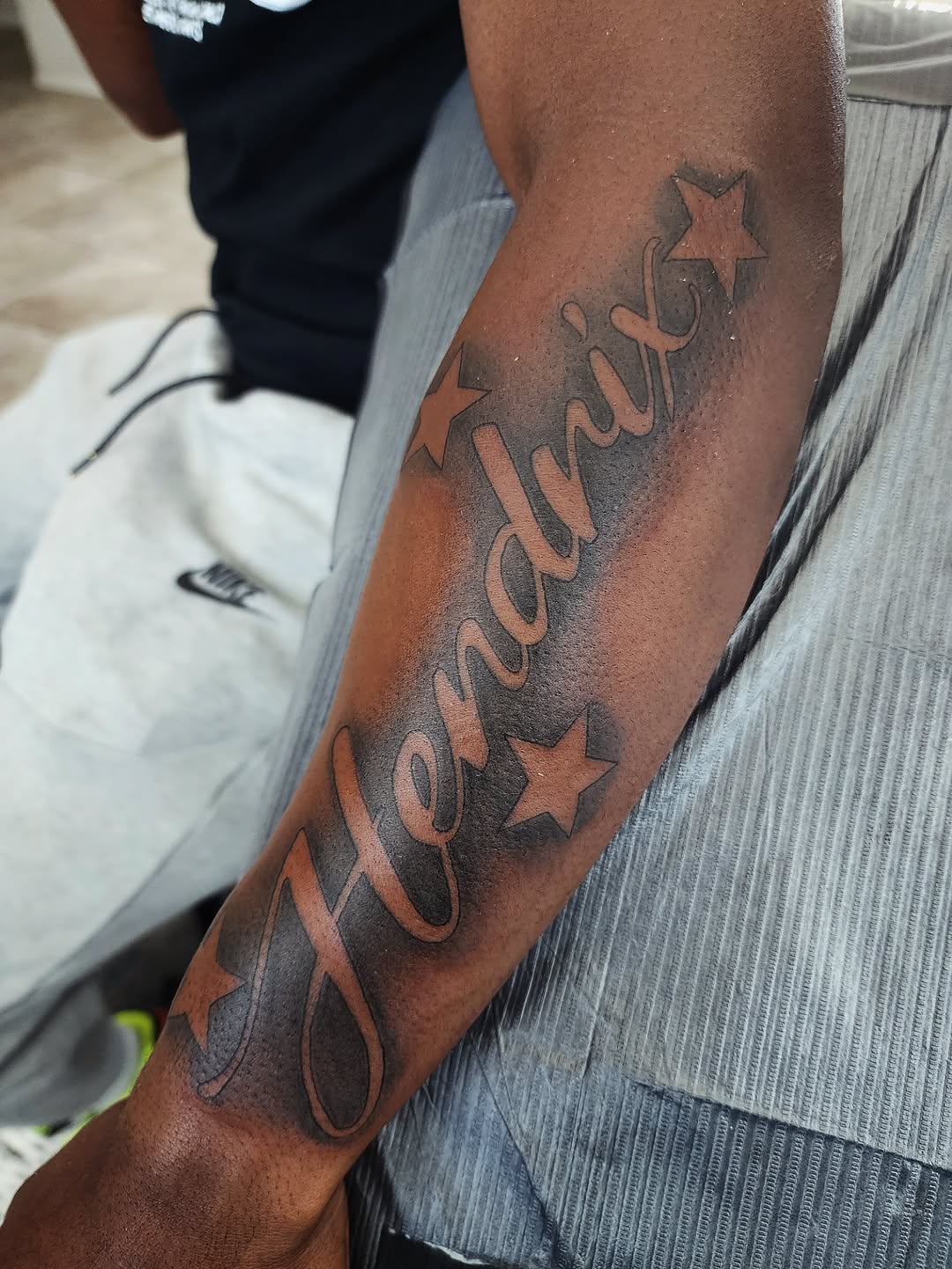 Tattoo by @consumer.inkslinger.artist — lettering_script, black_and_grey