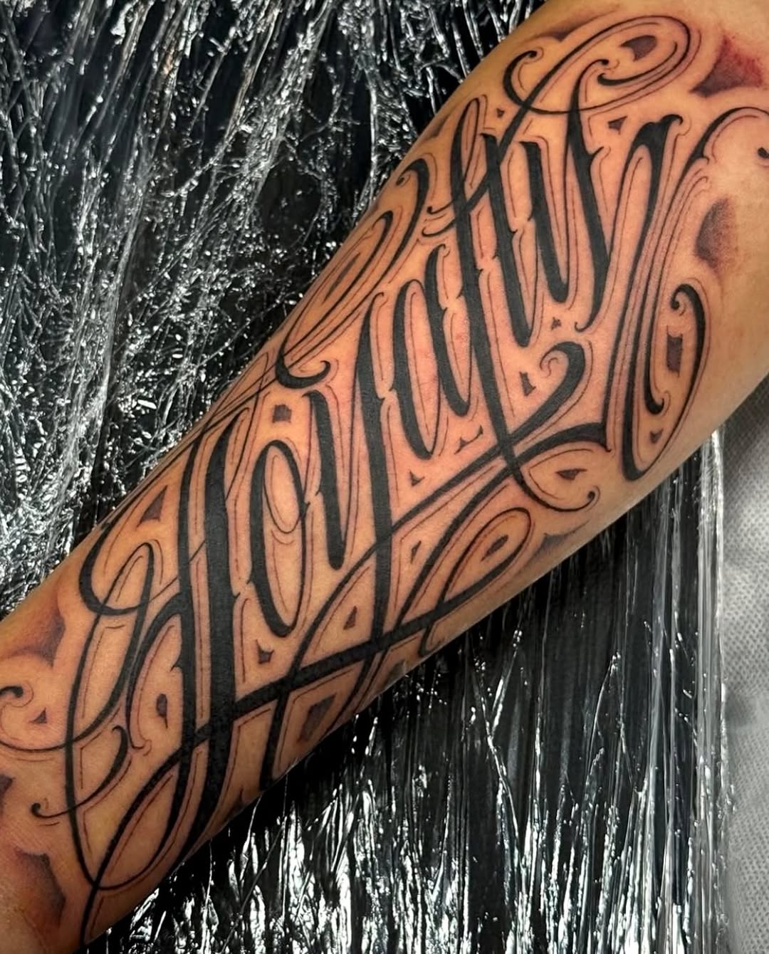 Tattoo by @dopeletterstattoo — lettering_script, chicano
